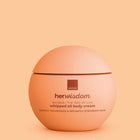 A round peach-colored jar of Avon Her Wisdom Baobab whipped oil body cream, set against a matching peach background.