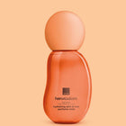 Avon Her Wisdom Baobab Hydrating Skin & Hair Perfume Mist in a translucent orange bottle with a matching rounded cap, set against a solid peach background.