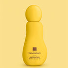A yellow Avon Her Wisdom bottle of indulgent glow bath & shower oil, centered against a matching soft yellow background.