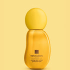 A bottle of Avon Her Wisdom Sim Sim Caring Skin & Hair Perfume Mist, featuring a translucent golden-yellow body and a matching rounded yellow cap, set against a solid pale yellow background.